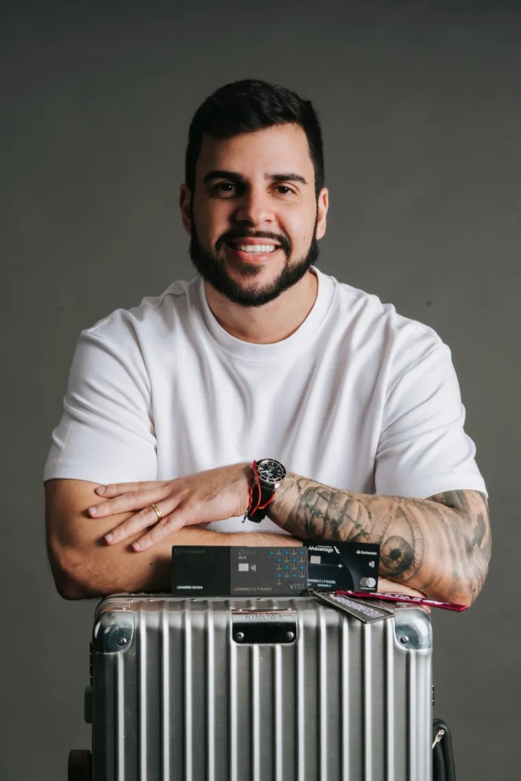 Leandro Portela com cartões black sobre a mala de viagem